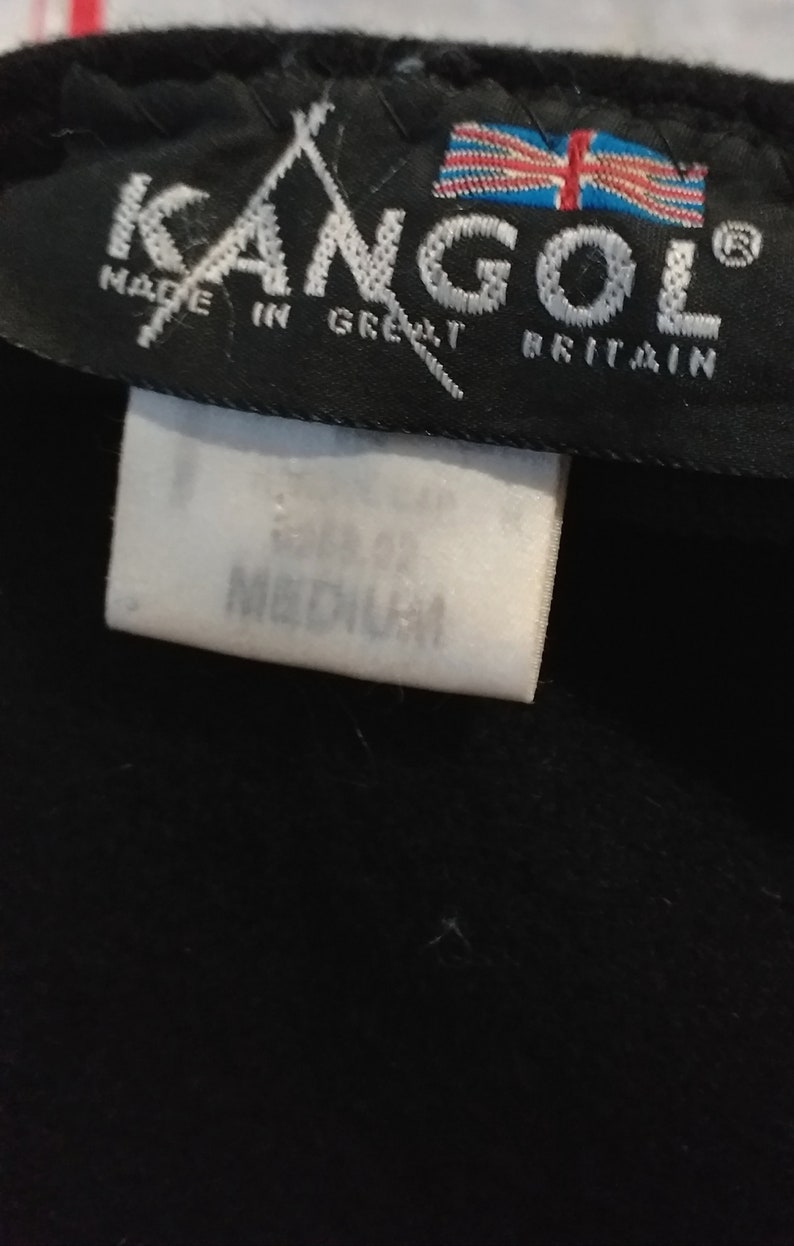 May include: Black Kangol hat with a white label that says "Made in Great Britain" and a white tag that says "Size 57.5 Medium".