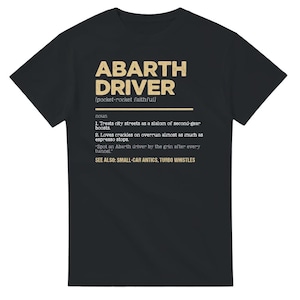 Peut inclure: T-shirt noir avec du texte doré qui dit "ABARTH DRIVER [pocket-rocket faithful] nom 1. Traite les rues de la ville comme un slalom de seconde vitesse 2. Aime les crépitements en surrégime presque autant que les arrêts d'espresso "Repérer un conducteur d'Abarth au sourire après chaque tunnel" VOIR AUSSI : FARCE DE PETITE VOITURE, SIFFLETS TURBO"