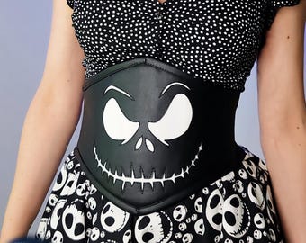 May include: Black corset featuring a white Jack Skellington face design. The corset is worn over a black and white polka dot top and a matching skirt with skull patterns. The design is from the movie "The Nightmare Before Christmas".