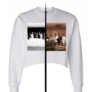 May include: White cropped sweatshirt featuring a split image. One side shows a group of people in suits and hats standing behind a large pile of packages. The other side shows a group of people in sunglasses standing behind stacks of money.