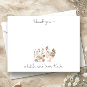 Puede incluir: Una tarjeta de agradecimiento blanca con una ilustraci&oacute;n de acuarela de dos pollos en un jard&iacute;n. El texto "gracias" est&aacute; escrito en la parte superior de la tarjeta y el texto "una peque&ntilde;a nota de Katie" est&aacute; escrito en la parte inferior de la tarjeta.