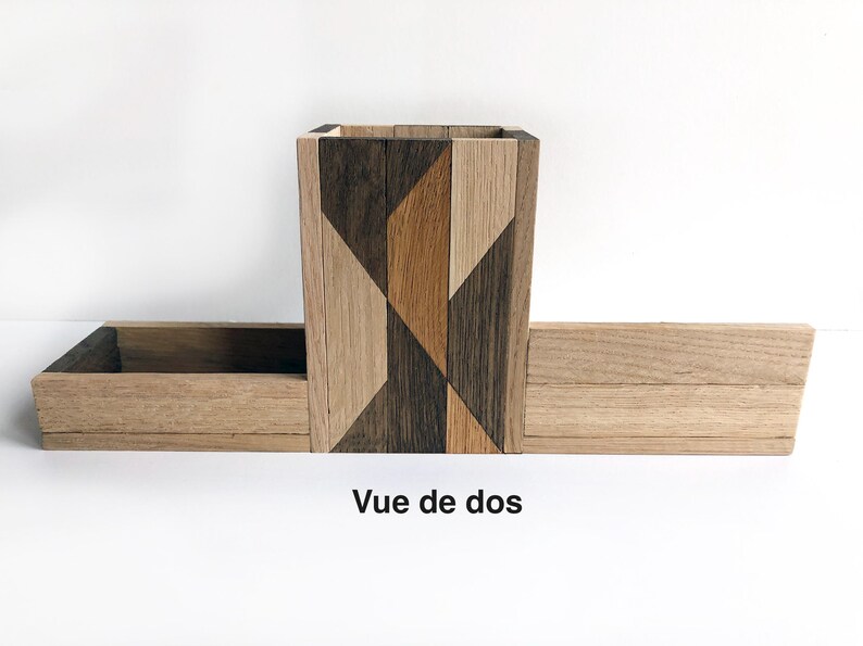 May include: A wooden organizer with a geometric pattern on the front. The organizer has a small box on top and a larger box on the bottom. The text "Vue de dos" is written below the organizer.