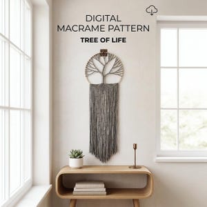 May include: A gray macrame wall hanging featuring a tree of life design within a circular frame, with long fringe and small beads. Text above reads: DIGITAL MACRAME PATTERN TREE OF LIFE. The piece is displayed on a wall above a wooden console table.