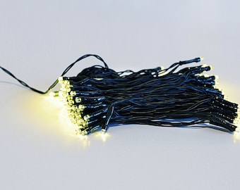 May include: A string of warm white LED fairy lights with black wire. The lights are bundled together and are ready to be strung up.