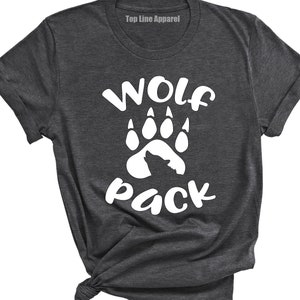 May include: A dark grey t-shirt with a white wolf paw print and the text "Wolf Pack" printed on the front.