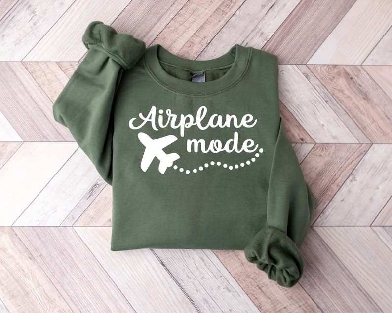 May include: A green sweatshirt with the text "Airplane mode" in white lettering and a white airplane graphic.