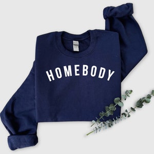 May include: A navy blue sweatshirt with the word "HOMEBODY" printed in white on the front.