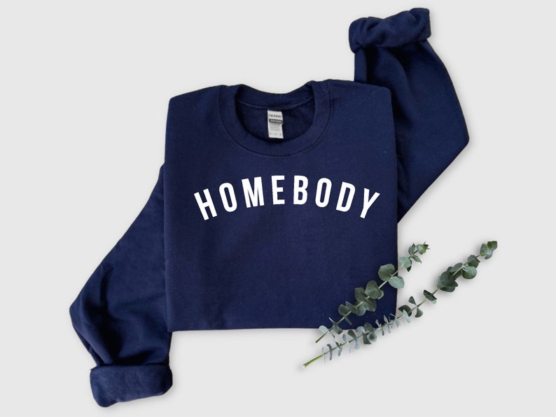 May include: A navy blue sweatshirt with the word "HOMEBODY" printed in white on the front.