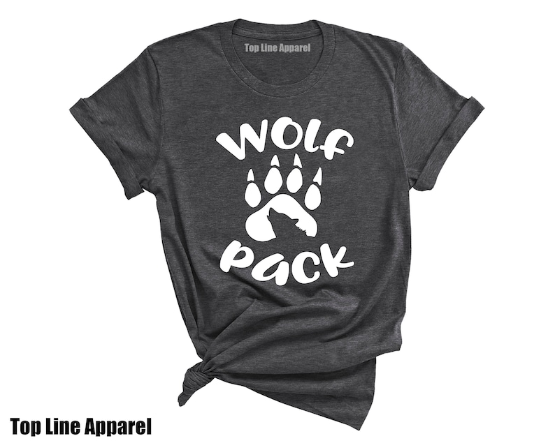 May include: A dark grey t-shirt with a white wolf paw print and the text "Wolf Pack" printed on the front.