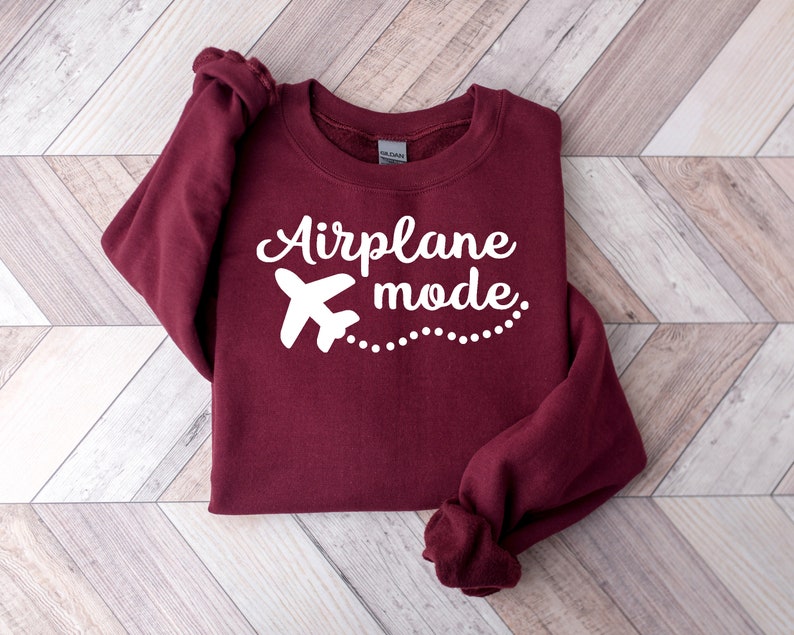 May include: A maroon sweatshirt with a white airplane graphic and the text "Airplane mode" in white.