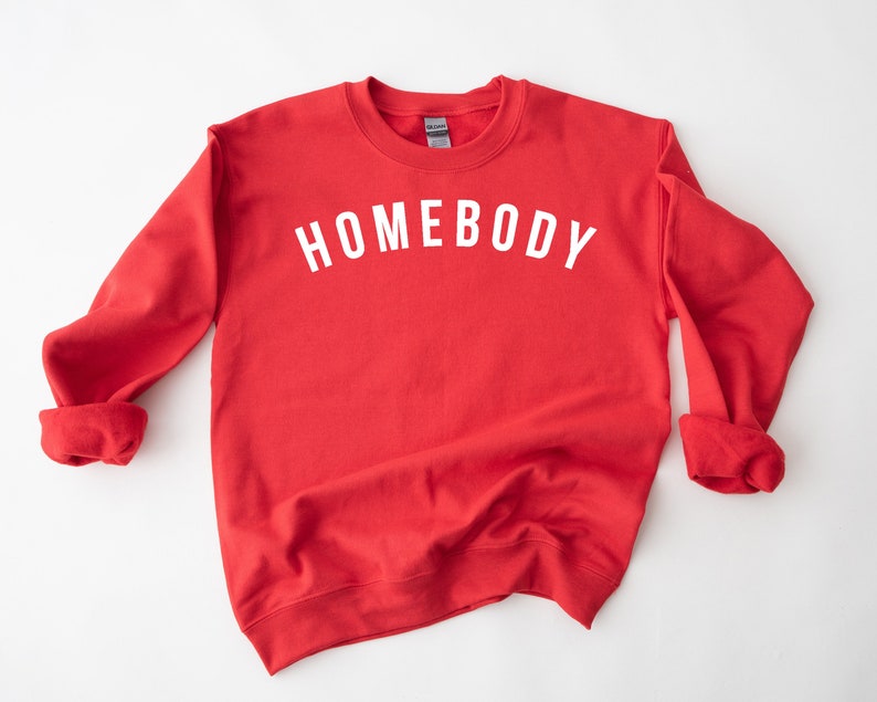 May include: Red sweatshirt with the text "HOMEBODY" in white lettering.