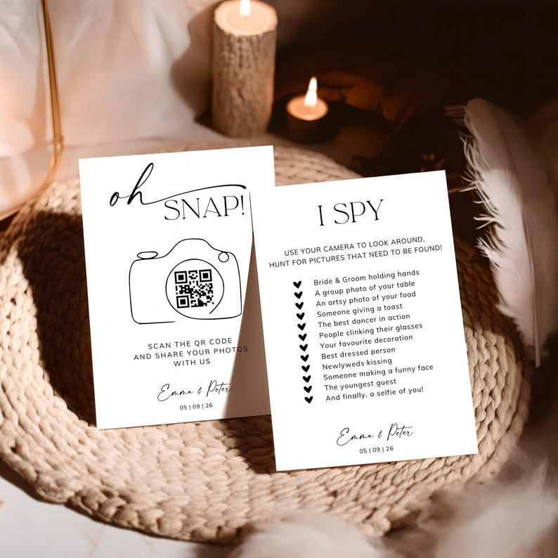 May include: Two white rectangular wedding cards with black text. One card features the text oh SNAP! with a camera icon containing a QR code, and the other lists an I SPY game with a checklist of photo tasks. Both cards are personalised with Emma & Peter and the date 05 | 09 | 26.