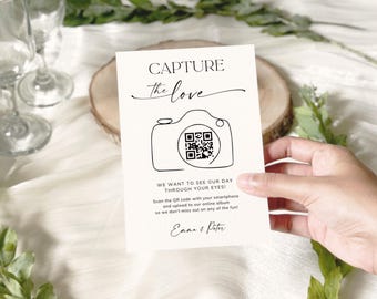 May include: A cream-coloured wedding invitation card featuring the text "CAPTURE the love" and a camera graphic with a QR code. The card also includes the text "WE WANT TO SEE OUR DAY THROUGH YOUR EYES!" and the names "Emma & Peter".