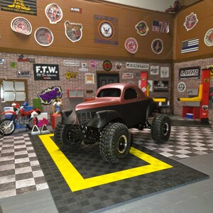 Pu&ograve; includere: Un modellino di camion personalizzato bicolore marrone e nero opaco, dotato di pneumatici fuoristrada sovradimensionati con cerchi argentati, una griglia anteriore e una cabina arrotondata, esposto in un diorama da garage.