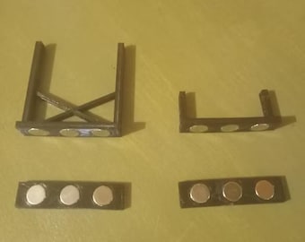 May include: Four black, 3D-printed components with embedded magnets. The components include two rectangular pieces with three magnets each, and two structural pieces, one with an X-shaped support and the other with an L-shape.