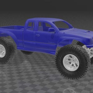 May include: A blue model pickup truck body with an extended cab, featuring a hood scoop and prominent wheel arches. The vehicle is equipped with large, black off-road tires mounted on white multi-spoke rims, showcasing a lifted suspension design.
