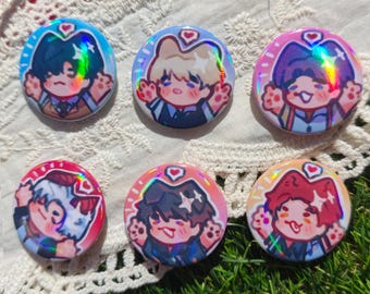 May include: Six circular pin-back buttons featuring holographic anime-style character illustrations. Each button displays a different character with cat-like features, raised hands, and a small heart icon above their head, set against colorful backgrounds.