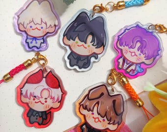 May include: A collection of six acrylic charms featuring cartoon characters with various hair colors and outfits. Each charm has a gold-colored clasp and a colorful lanyard. The charms are in shades of purple, black, brown, red, and white.