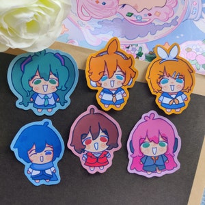 May include: Six colorful cartoon character stickers with different expressions. The stickers are printed on white paper and have a glossy finish.
