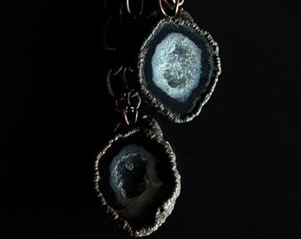 May include: Two silver and black agate pendant necklaces with a copper chain. The agate is a natural stone with a white and gray crystal inside.
