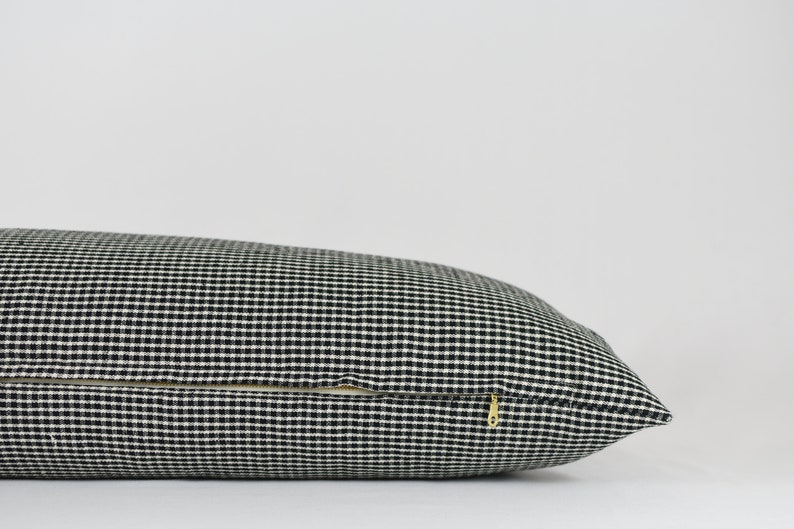 May include: A black and white gingham pillow with a zipper closure.