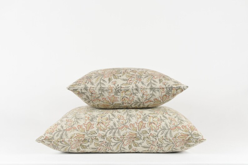 May include: Two decorative throw pillows with a floral pattern in shades of beige, brown, and orange.