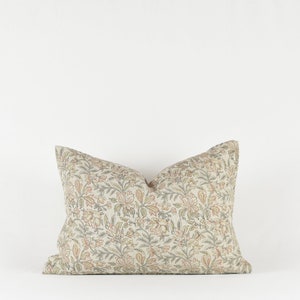 May include: A decorative cushion with a floral pattern in shades of beige, green, and orange.