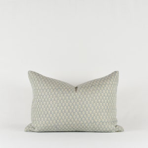 May include: A light blue throw pillow with a white geometric pattern.