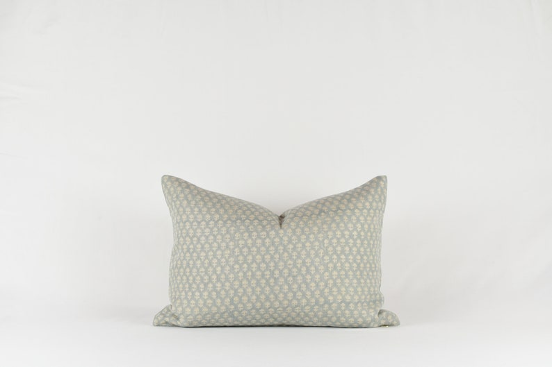 May include: A light blue throw pillow with a white geometric pattern.