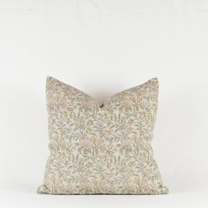 May include: A decorative throw pillow with a floral pattern in shades of beige, green, and orange.