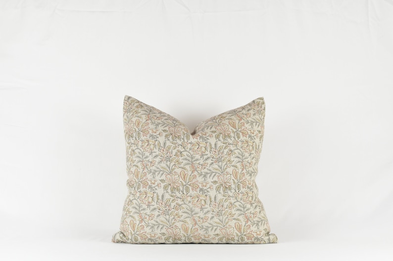 May include: A decorative throw pillow with a floral pattern in shades of beige, green, and orange.
