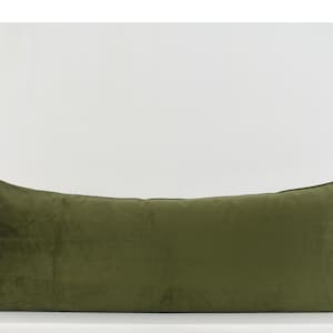 May include: A long, rectangular, olive green velvet pillow. The pillow is made of a soft, plush fabric and has a simple, elegant design.
