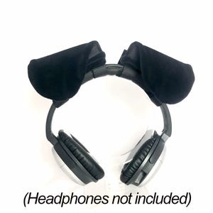 K&ouml;nnte beinhalten: Ein Paar schwarze Tierohren aus Samt zur Befestigung an einem Kopfband. Die Ohren sind weich, abgerundet und dunkel gef&auml;rbt. Der Text (Headphones not included) ist in Schwarz am unteren Rand des Bildes auf wei&szlig;em Hintergrund aufgedruckt.