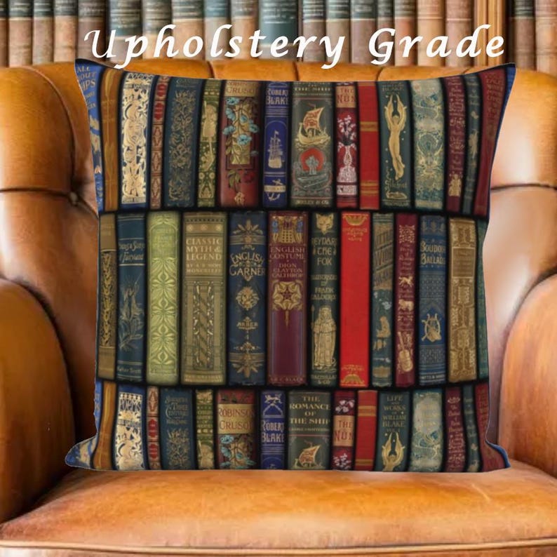 Puede incluir: Coj&iacute;n decorativo con una impresi&oacute;n de una estanter&iacute;a llena de lomos de libros antiguos. El coj&iacute;n tiene un borde azul oscuro y el texto "Upholstery Grade" en la parte superior. Los libros son de varios colores, incluyendo rojo, dorado y azul.