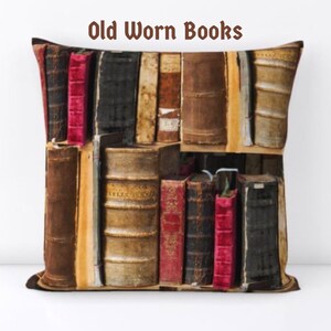 Puede incluir: Coj&iacute;n cuadrado con una impresi&oacute;n de libros viejos y desgastados. Los libros son de varios tama&ntilde;os y colores, incluyendo marr&oacute;n, negro y rojo. El texto "Old Worn Books" est&aacute; impreso en la parte superior.
