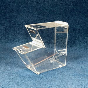 May include: A clear acrylic bin with a hinged lid. The bin is designed to hold and dispense bulk items like candy, nuts, or cereal.