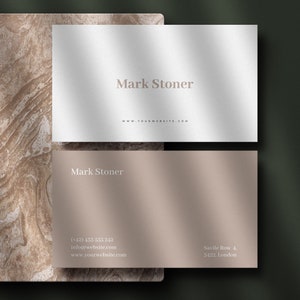 May include: A white and a beige business card with the name "Mark Stoner" and contact information printed on them. The cards are on a brown marble background.