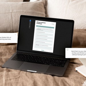 May include: A laptop computer displaying a 30 Day Gratitude Challenge worksheet. The worksheet is a fillable PDF that can be sent to clients. The laptop is on a brown linen bedspread.
