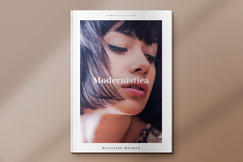 May include: A magazine cover mockup with a white background and the text "Modernistica" in a simple, clean font. The cover features a close-up photo of a woman with dark hair and a neutral expression.