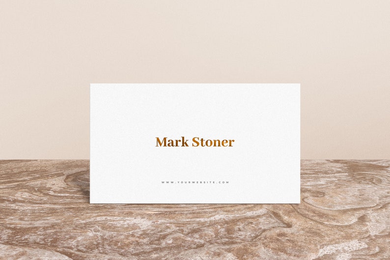 May include: White business card with the text "Mark Stoner" in gold lettering and the website address "www.yourwebsite.com" printed below.