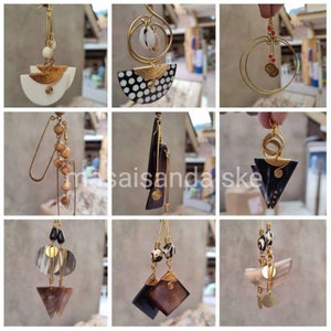 May include: Nine pairs of earrings featuring a variety of materials and designs, including wood, shell, and metal. The earrings are all handmade and have a unique, bohemian style.