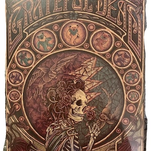May include: A vintage-style illustration of a skeleton with a rose in its hand, surrounded by a colorful mosaic pattern and the words "Grateful Dead".