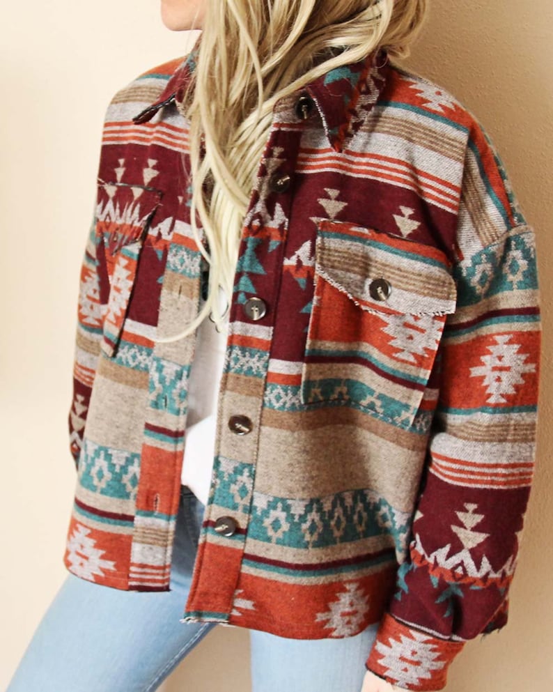 Peut inclure: Une chemise &agrave; manches longues boutonn&eacute;e avec un motif d'inspiration sud-ouest dans des tons de rouge, orange, turquoise et marron. La chemise a une coupe d&eacute;contract&eacute;e et une silhouette l&eacute;g&egrave;rement ample.