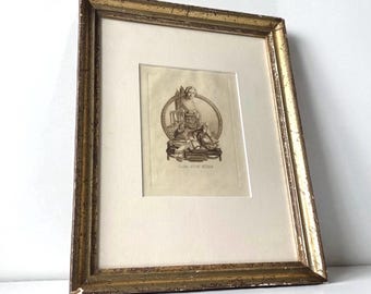 Puede incluir: Un grabado antiguo enmarcado con un marco de madera dorada desgastada. El grabado presenta una ilustración detallada en blanco y negro de figuras clásicas dentro de un marco ovalado. El grabado está sobre un passe-partout crema.