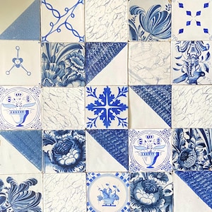 May include: A collection of square ceramic tiles with blue and white floral and geometric patterns. The tiles feature various designs, including flowers, leaves, and abstract shapes. The tiles are arranged in a grid, showcasing the variety of patterns.
