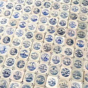 May include: A collection of antique, square ceramic tiles with hand-painted blue and white designs. Each tile features a central circular image depicting various scenes, including landscapes, figures, and boats. The tiles are arranged closely together.
