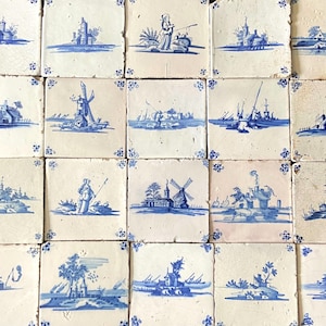 May include: A collection of antique square tiles, each featuring a unique blue and white hand-painted landscape scene. The designs include windmills, buildings, and figures, with decorative floral corner accents. The tiles are arranged in a grid.