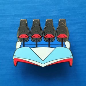 Puede incluir: Un colorido pin de esmalte con un vagón de montaña rusa con cuatro asientos. Los asientos son negros con detalles rojos, y el vagón tiene un diseño azul y blanco con ribetes rojos. El pin tiene un contorno dorado.