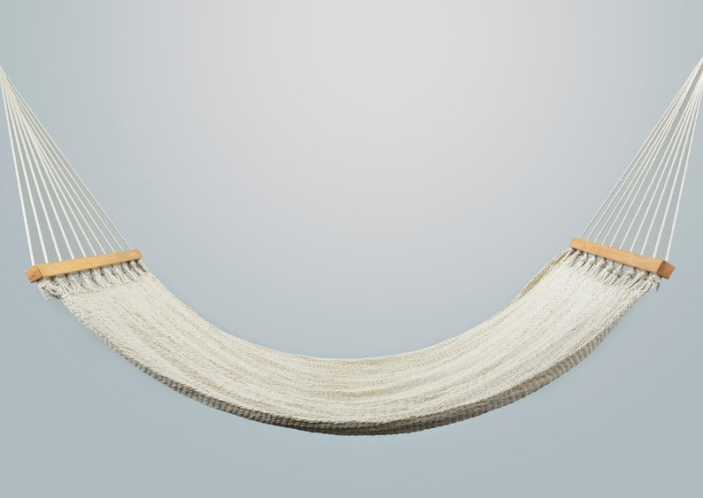 May include: A white hammock with wooden spreader bars hangs against a light gray background.