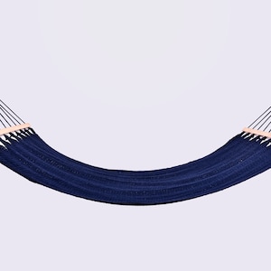 May include: A navy blue hammock with wooden spreader bars. The hammock is hanging from two ropes.